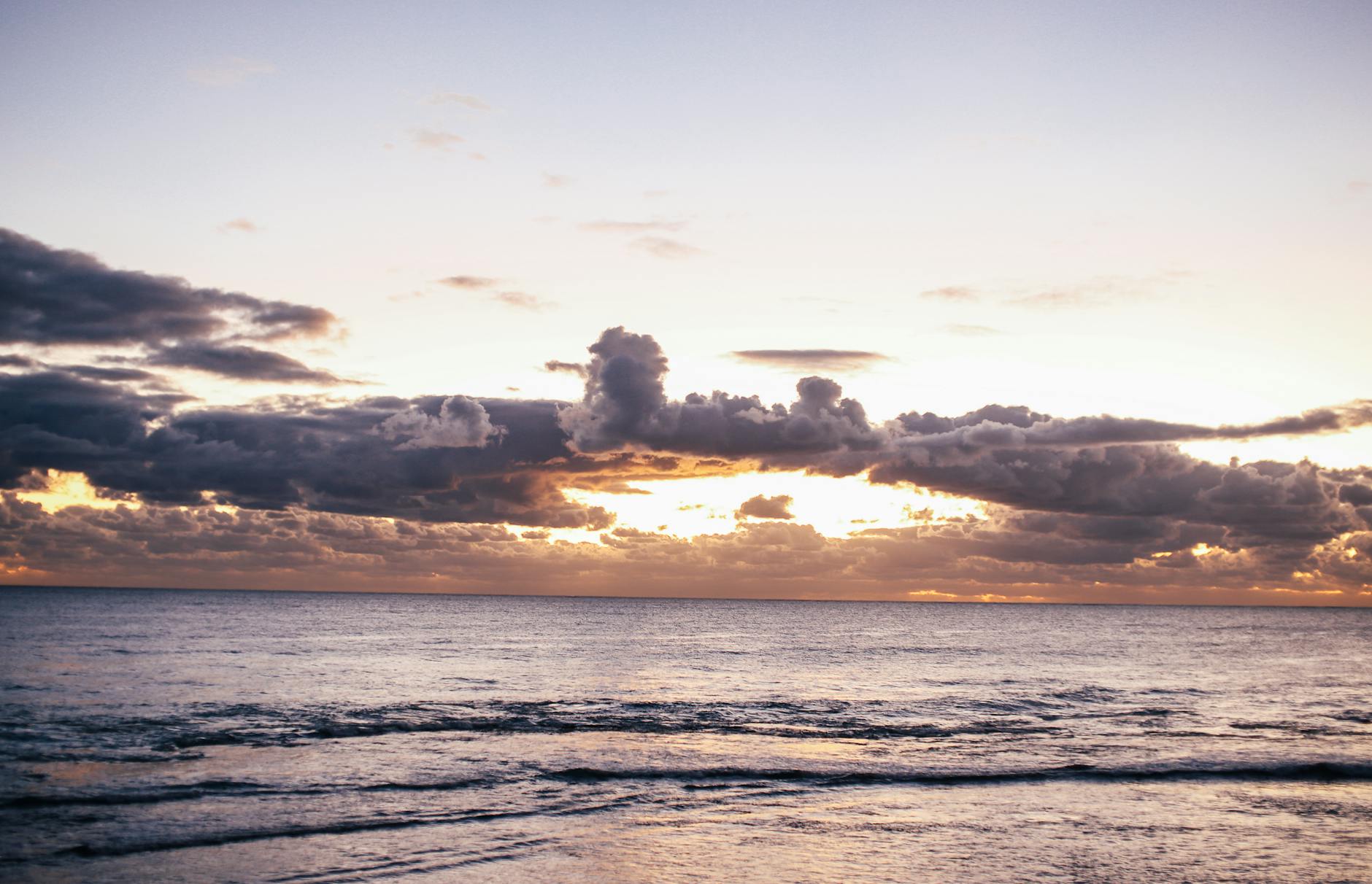 Tranquil ocean scene with clouds and sunset glow, perfect for relaxation themes.