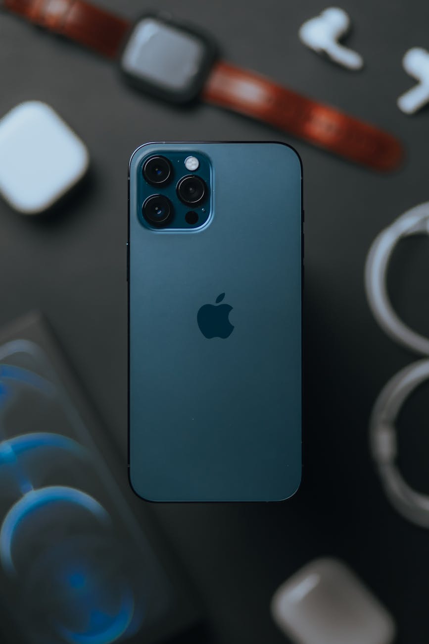 From above of contemporary expensive smartphone with high quality cameras against blurred devices placed on table