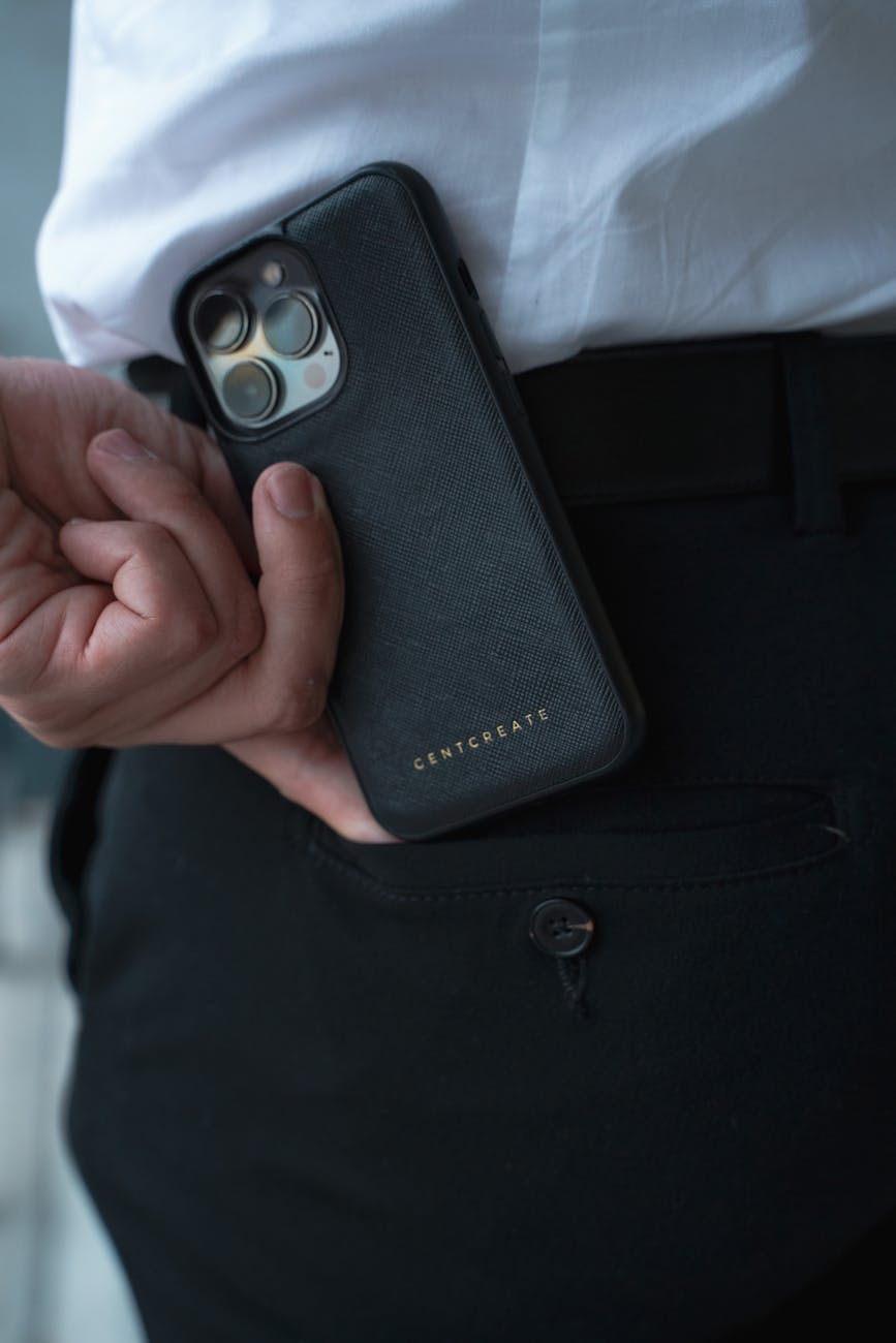 Close-up of a man holding a smartphone with a luxury case indoors.