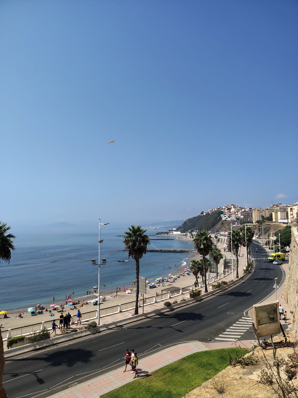 Stunning view of a coastal road along a busy beach in Algiers, Algeria.