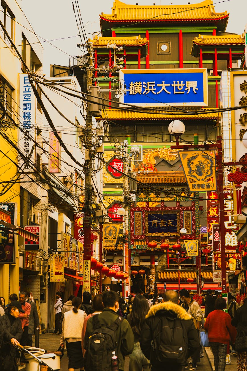 Bustling view of Yokohama's Chinatown with colorful signage and vibrant street life on a busy day.