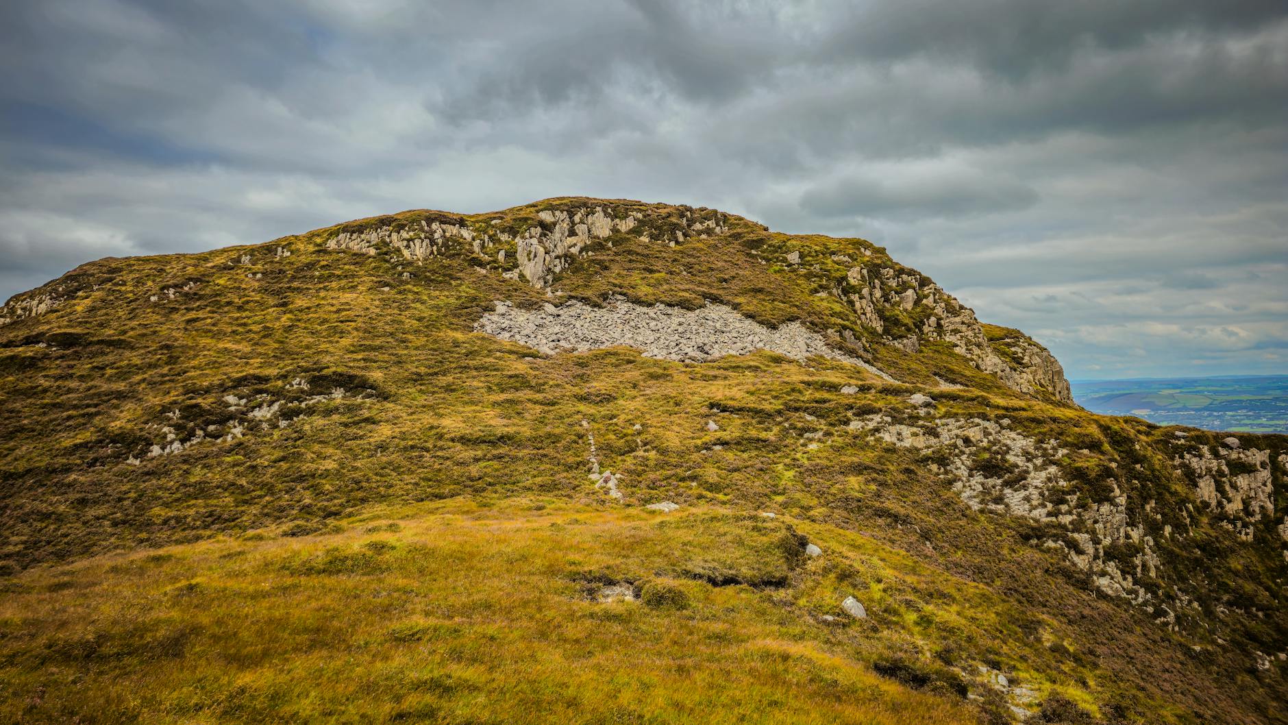 Stunning view of rugged mountain landscape under a cloudy sky in Крохейн, Ireland.